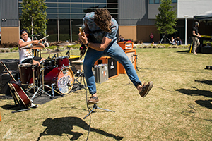 musician jumping in the air with a guitar